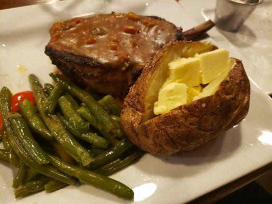 Smoked pork chop with sauteed green beans and baked potatoe