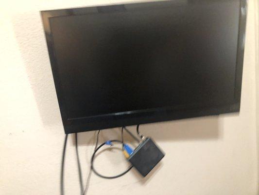 LED TV has the cable box dangling without support.