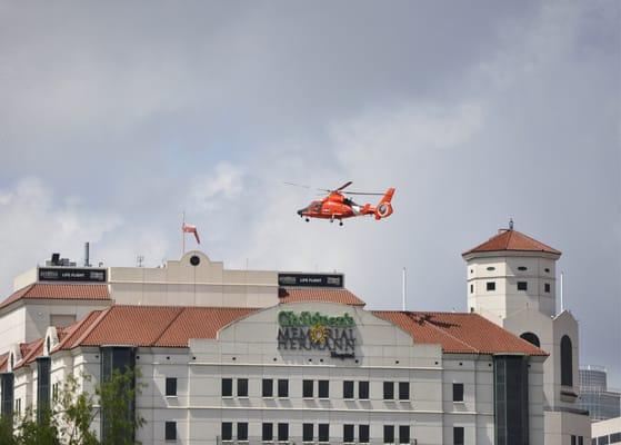 A US Coast Guard HH-65C Dolphin helicopter performing its monthly training mission at Children's Memorial Hermann.