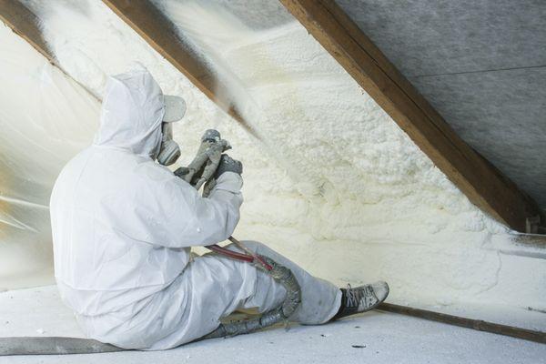 Professional spray foam insulation contractors completing a wall insulation installation.