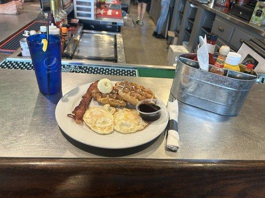 Waffle Combo w/ eggs over medium, bacon, & a water.