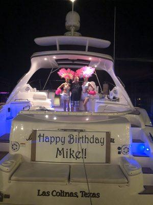 Showgirls arrived on this yacht with the birthday cake.  This picture is of them with my husband after they arrived.  It was perfect.