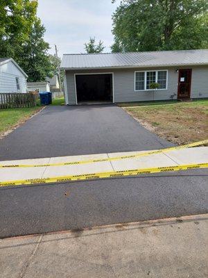 New asphalt on both sides of my new sidewalk.