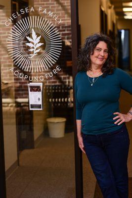 Anna Werderitsch standing in front of her office with her new logo!