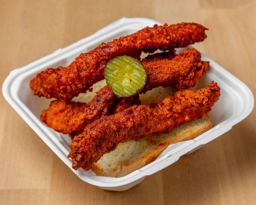 Mild Chicken strips with a pickle and toast.