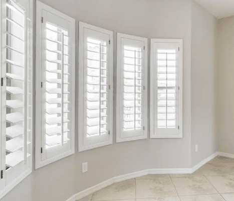 painted classic white shutters on curved wall.