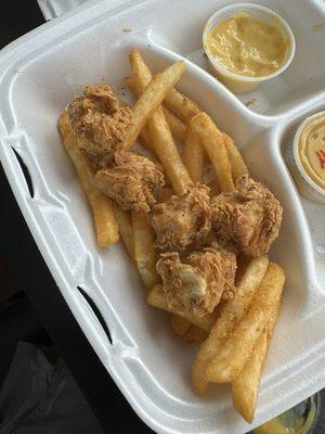 Chicken nuggets with fries and honey mustard.