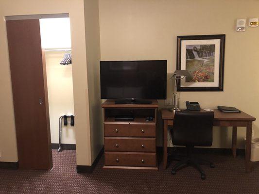 Desk, TV, and closet across from bed