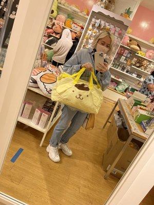 Me holding a pompompurin travel bag