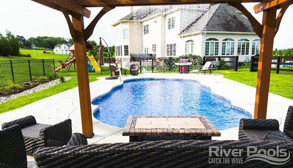 Inground C40 fiberglass swimming pool with waterfall from pergola