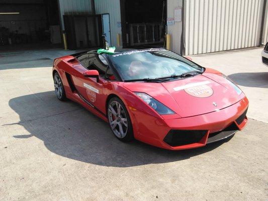 Full wrap. This Lamborghini was black and is now flat red. Full color company decals were added to the doors and hood.