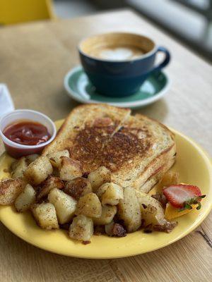 Italian Breakfast Sandwich with pesto, prosciutto, provolone, tomato, and egg on sourdough with a side of fried potatoes