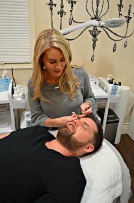 La Jolla Brow and Beauty Owner Marlena Freeman grooming a client's brows.