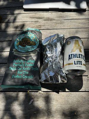 For size comparison, we see the lobster roll between a kettle chip bag and a nonalcoholic beer (not available at the truck).