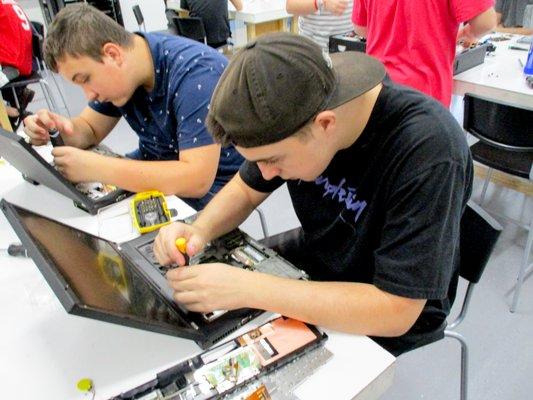 Students get an inside look into a laptop's hardware in Technology.