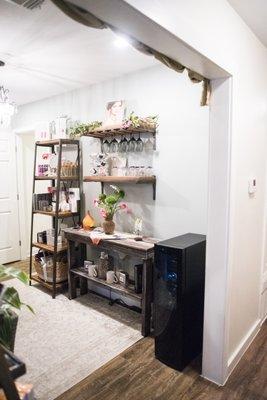 A hallway displaying Audrey McCarthy's skin care products. We also have refreshing drinks and coffee or tea available on the house!