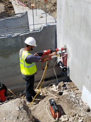 Completing core drilling for elevator sumb pump on a  multi-family complex job site.