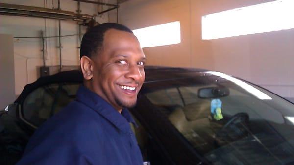 Shaun Auto Spa's Gloss Boss, smiling confidently that customer will be happy with his Ultra Shine treatment for his car