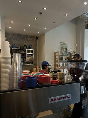 Espresso machine with ceramic cups on top.