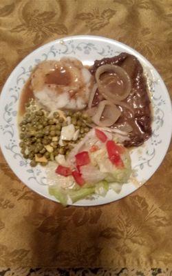 Liver and onions and brown gravy, mashed potatoes, salad and english peas I what's on this meal.