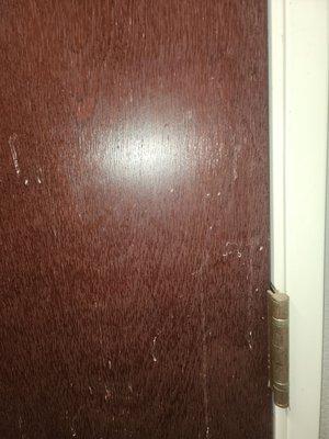 Back of door in bathroom where it looks as though something was splashed on it and was never removed.