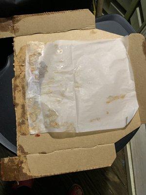 The wax paper covering placed on top of the contents in the pizza bowl.