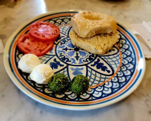 Toasted plain bagel with pesto, tomato, & cream cheese