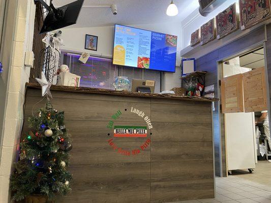 Inside payment counter and pickup for to go orders. Menu on rotation on tv screen.