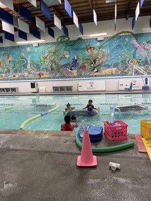 Our son is in the guppy stage and is learning how to swim his own with one of the instructors while the other kids wait their turn