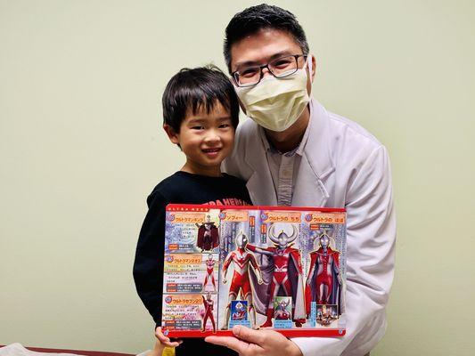 Our happy pediatric client showing off his collection of books