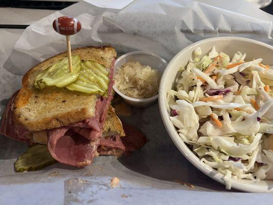 Reuben with coleslaw , sauerkraut on the side.