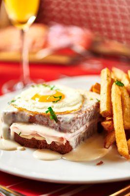 Croque Madame - griddled bistro ham & gruyere on brioche topped with mornay and a sunnyside up egg, chips