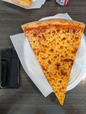 Pizza slice with phone for scale