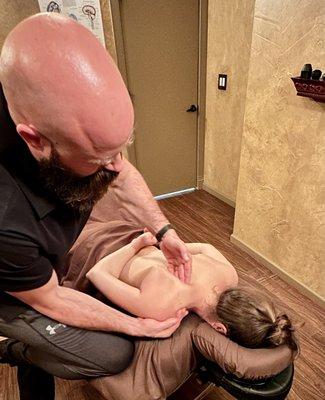 Jarrett Smilie using a scapular rotation technique to release tension in client's upper back.