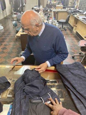 Tailor Sunder checks how much extra material within my jacket cuffs and inseams he has to lengthen my suit.