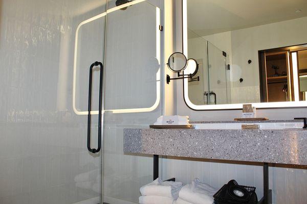 The bathroom was outfitted with a large vanity, lit mirror, Beekman 1802™ bath products, and a rain showerhead.