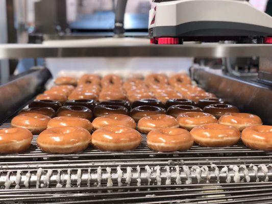 Hot doughnuts traveling through a waterfall of glaze! OMG!!!