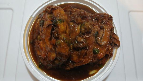 Vegetable Egg Foo Young: Three fluffy egg omelets with vegetables in savory brown sauce, garnished with scallions