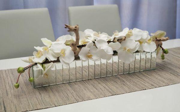 Mirrored vase with orchids and driftwood