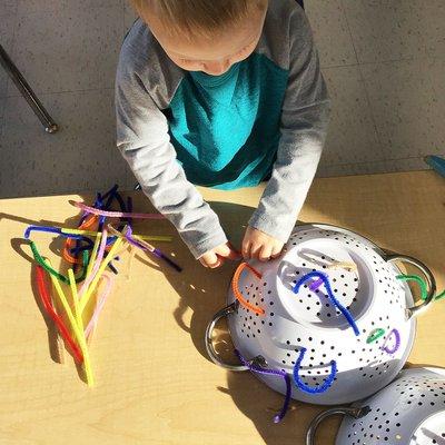 Play-based, Reggio-inspired. Toddler exploring with pipe cleaners