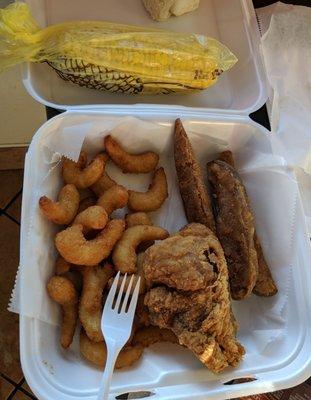 Fried shrimp, spicy chicken breast, potato wedges and corn on a cob