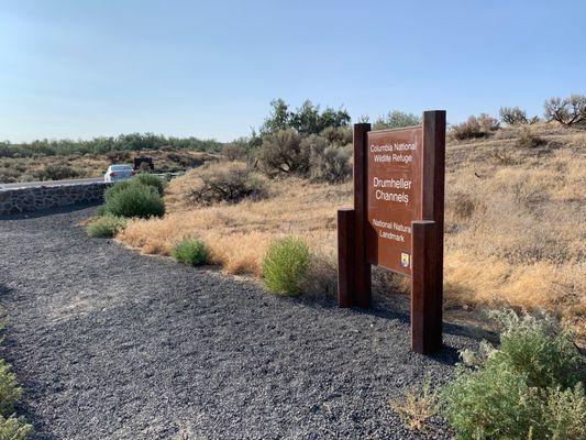 Official sign on the right and parking lot in the distance on the left.