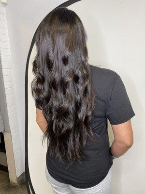 Woman's long layered hair cut with some bouncy curls