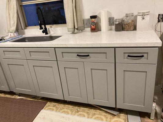 Quartz countertop and restaurant style kitchen faucet installed.  Still more work to be done on my part; drawer pulls, tiling, and new floor