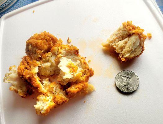 The tiny piece of actual chicken is next to the nickel for scale. Larger amount was all the dough on one "wing"