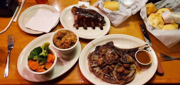 20 oz. Bone-In Ribeye with sautéed mushrooms and onions done medium-rare, fresh vegetables, rice, ribs.