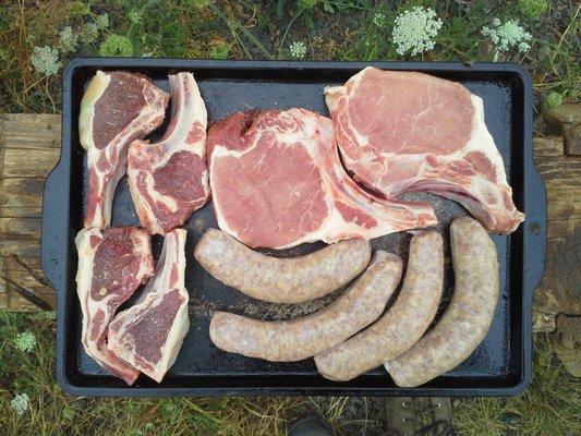 Pork chops, lamb chops, and bratwurst, ready for the grill.