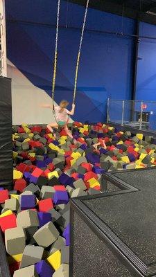 Swings and trapeze to foam pit.