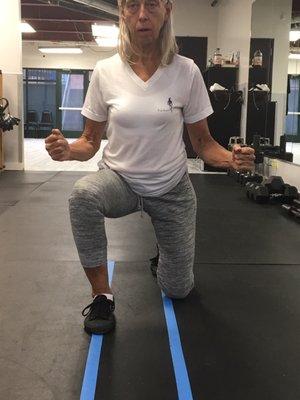 Using tape lines with Judy to ensure perfect form and alignment while she wears her super stylish and comfortable Human Fitness V-neck!