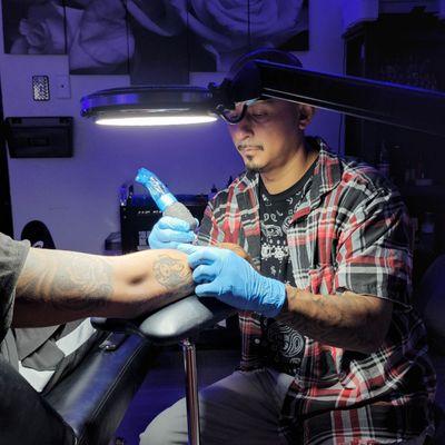 Eddie Coronado working on a tattoo at Live Through This Tattoos.